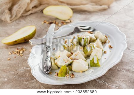 Delicious salad with pear, blue cheese sauce and almonds