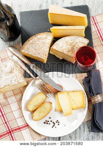 Different french cheeses with a glass of red wine