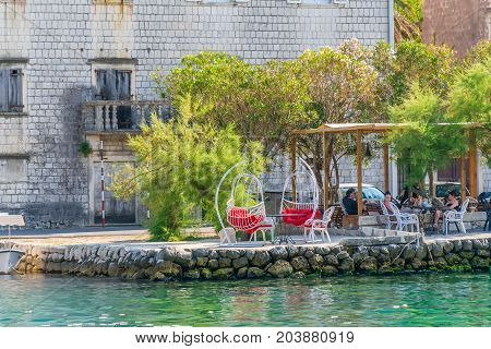 Montenegro, Prcanj - June 04/2017: Tourists Come To The Shore Of The Bay Of Kotor In The Evening To