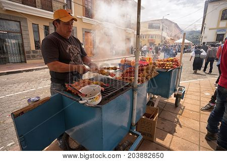 April 14 2017 Cotacachi Ecuador: street vendor preparing food on the wood fired barbecue during Easter procession