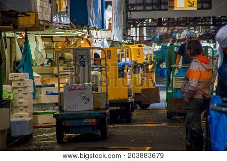 TOKYO, JAPAN JUNE 28 - 2017: Unidentified workers with a small cargo yellow machine, inside of a Fish Market Tsukiji in Tokyo Japan, Tsukiji Market is the biggest wholesale fish and seafood market in the world.