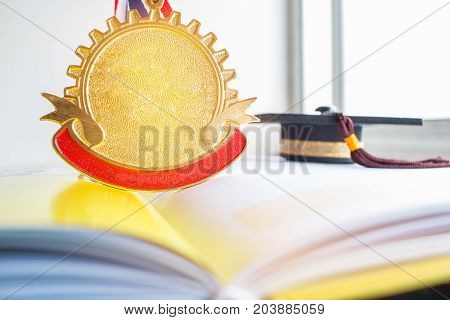 Golden medals and Graduation cap on book graduate education in university Competitions and Education study concepts. Success in study famous institution Concept of winner abroad international.