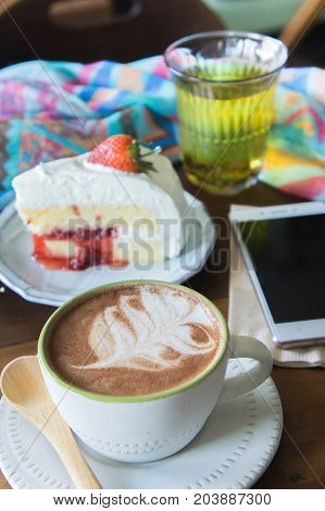 coffee cup and delicious cake strawberry and relax time moblie on table in coffee shop