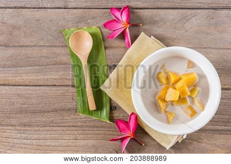 cooked casava in syrup serve with tiny cup of coconut milk.