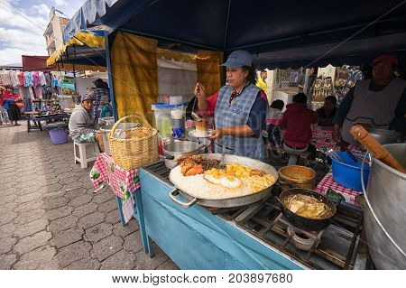 April 29 2017 Otavalo Ecuador: indigenous quechua women are preparing food on the street in the Saturday market