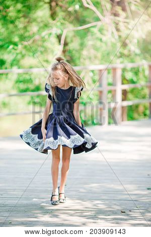 Adorable little school girl with notes and pencils outdoor.