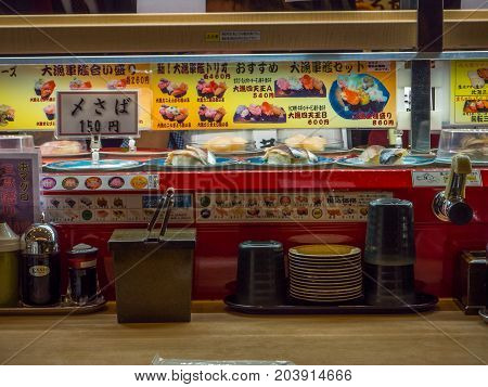 TOKYO, JAPAN -28 JUN 2017: View of assorted japanesse food over a table, inside of a kaitenzushi conveyor belt sushi restaurant in Tokyo, Japan.