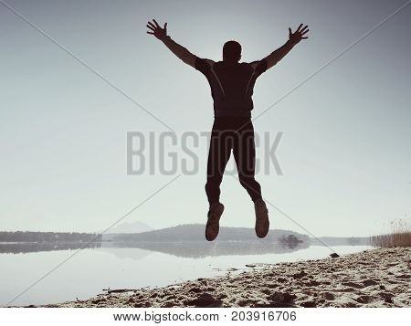 Jumping Man. Sportsman Crazy Jumping  And Jogging On Beach During The Sunrise