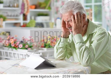 Portrait of a happy senior man using digital tablet