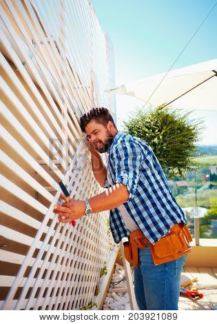 Young Adult Man Decorating The House Wall, By Setting Up The Wooden Trellis For Climbing Plants