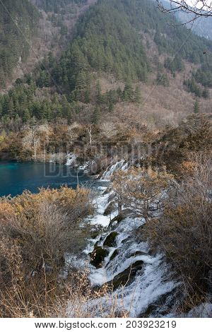 Waterfalls in JiuZhaiGou. Jiuzhaigou , Sichuan, China. Picturesque nature in JiuZhaiGou. Flow of water over the rocks into the lake against the backdrop of mountains and sky