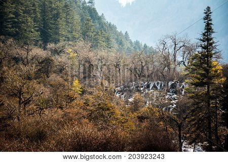Waterfalls in JiuZhaiGou. Jiuzhaigou , Sichuan, China. Picturesque nature in JiuZhaiGou. Flow of water over the rocks into the lake against the backdrop of mountains and sky