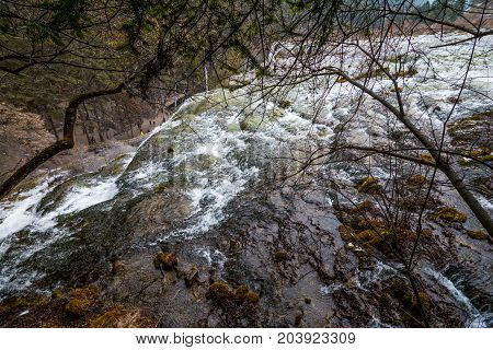 Waterfalls in JiuZhaiGou. Jiuzhaigou , Sichuan, China. Picturesque nature in JiuZhaiGou. Flow of water over the rocks into the lake against the backdrop of mountains and sky
