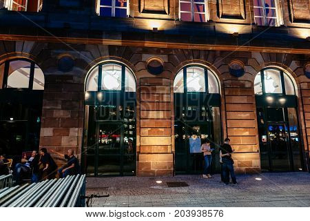 STRASBOURG FRANCE - SEPT 18 2014: Night view of Apple Store facade builing with impatient customers waiting in queue and tents for the upcoming Apple iPhone Apple Watch and other new products