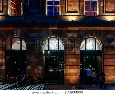 STRASBOURG FRANCE - SEPT 18 2014: Night view of Apple Store facade builing with impatient customers waiting in queue and tents for the upcoming Apple iPhone Apple Watch and other new products