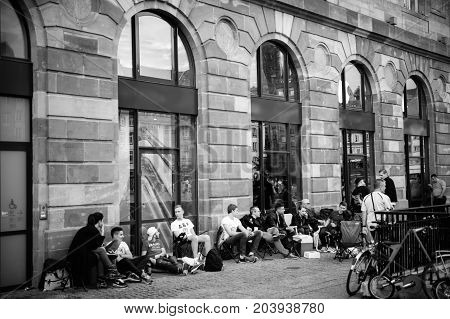 STRASBOURG FRANCE - SEP 9 2014: Customers waiting outside Apple Store prior the launch day of the newest iPhone Apple Watch iPad iMac computers - large Apple Store facade with computer Apple logotype