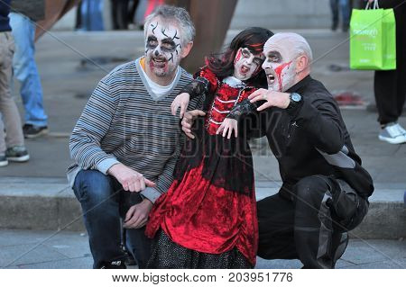 Girl With His Father And Another Man Dressing Hallowen Custom And Doing An Scary Face Before The Gal