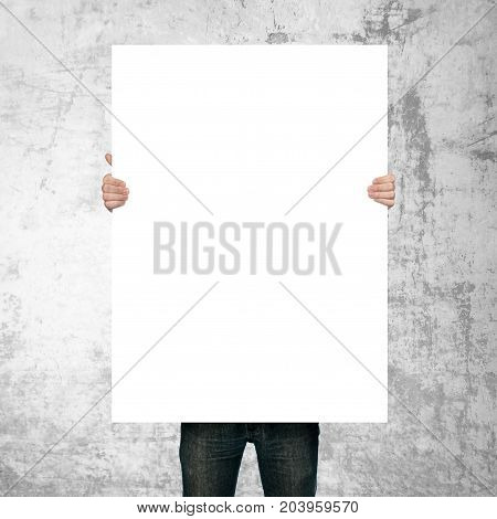 man holding blank poster on grunge background