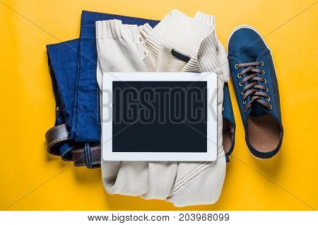 Fashionable men's clothing. Jeans and shoes on yellow background