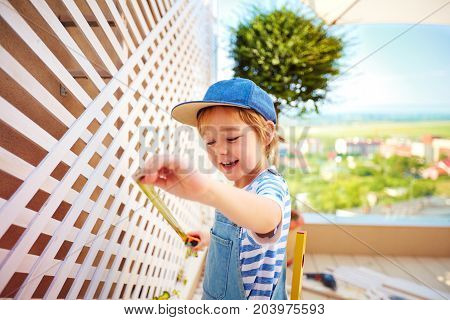 cute happy boy helping to set up a trellis on patio