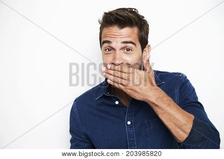 Guy stifling giggles in blue shirt portrait