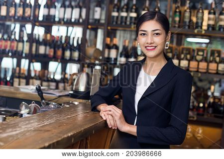 Young Asian Woman Restaurant Standing With Happy Emotion. Woman Present Wine For Customer At Bar. Wo
