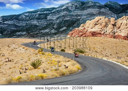 Motorcyclists riding a road into the dessert mountains