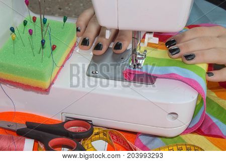 processes of sewing on the sewing machine sew women's hands sewing machine. Female tailor threading leather material on sewing machine. designer making a garment in her workplace