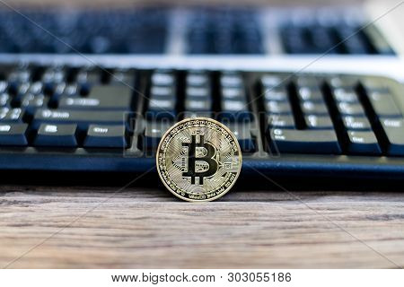 Bitcoin With Black Keyboard On Old Wood
