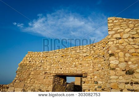 Ruins Of A Stone Wall Of An Ancient Fort With Blue Sky - Muttrah Fort, Muscat, Oman.