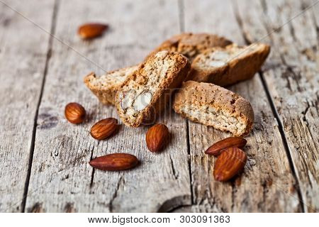 Fresh homemade Italian cookies cantuccini heap and almond seeds on ructic wooden table background.