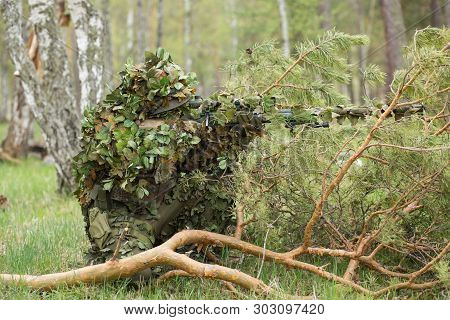 Camouflaged Sniper In The Forest