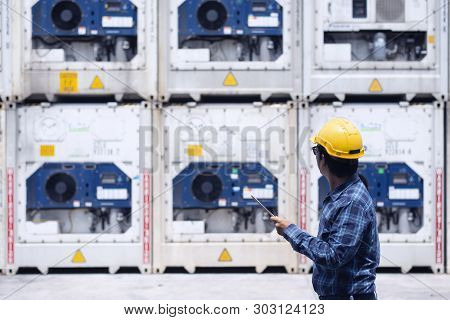 Reefer Technician Is Taking Care Of Reefer Container At The Port While Working With Tablet To Monito