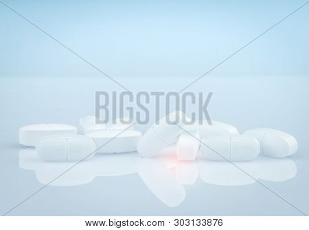 Pile Of White Oblong Tablets Pills On Gradient Background. White Antibiotic Tablet Pills. Pharmaceut