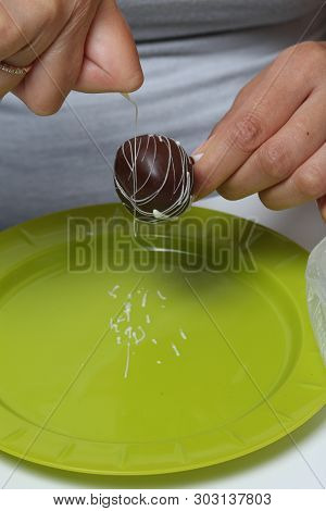 A Woman Decorates With The Help Of White Chocolate Popcake Glazed With Dark Chocolate.