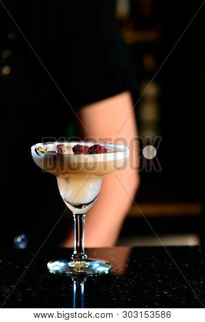 A Lifestyle Photo Of A Clover Club Alcoholic Drink In A Cocktail Glass, Standing On A Steel Barstand
