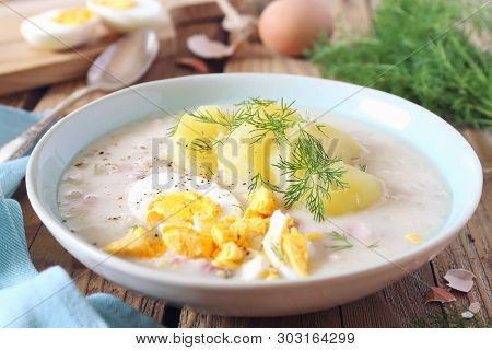 Traditional Polish Soup Zurek. Sour Soup With Sausage,  Potatoes And Eggs In Ceramic Bowl. Rustic St