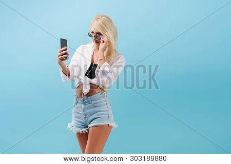 Young Slender Blond Girl With Long Hair Listens To Music On Headphones And Dances, Throws Back Her H