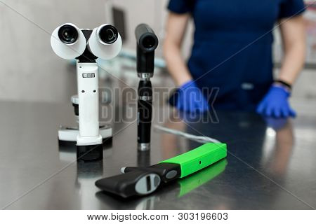 Medical Professional Ophthalmologist Tools Like Slit Lamp, Ophthalmoscope, Tonometer Lay On Metal Ta