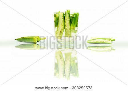 Popular Okra Drink Isolated On White With Some Okra Pods In Water And Some Of Them On The Surface An