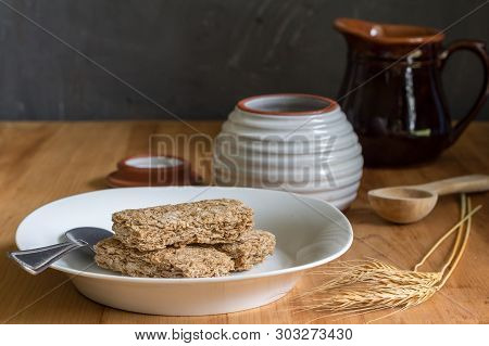 Wheat Cereal Bars Dry In Breakfast Plate On Wooden Table With Wheat Ears In Foreground And Honey And