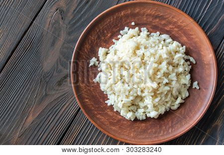 Portion Of Risotto On The Wooden Table
