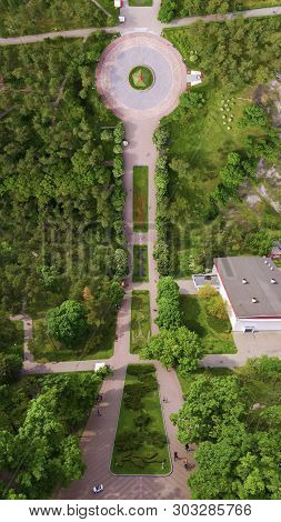 Flying Drone Above The Park. View Of The Trees And Walkways. Top View Of The Park. Photo In The Styl