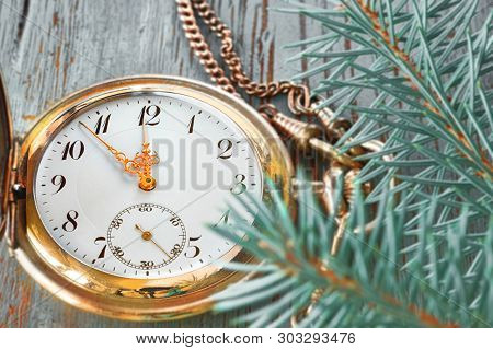 Vintage Pocket Watch Showing Five To Twelve On Gray Rustic Background With Fir Twigs And Golden Deco