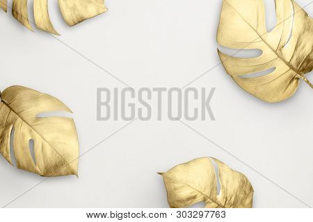 Gold split-leaf philodendron frame on white marble background illustration
