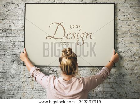 Blonde girl hanging a frame mockup