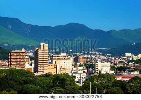 A Sunny Day In A Resort Town Of Beppu, Japan, With A View Of Mountains Embracing The City