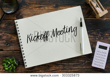 Top View Of Magnifying Glass,plant,pen,calculator,sand Clock And Notebook Written With Kickoff Meeti