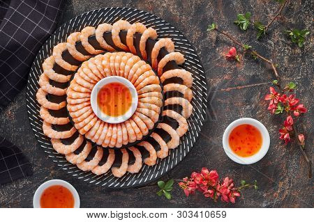 Zesty Lemon And Garlic Prawns Served On A Dark Plate With Sweet Chili Sauce, Flat Lay On Dark Backgr
