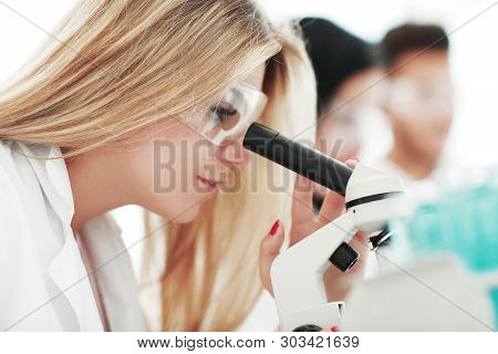 Close Up.a Modern Female Scientist Looks Into A Microscope In A Laboratory